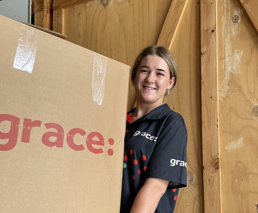 Kat from Sunshine Coast Grace lifting a box